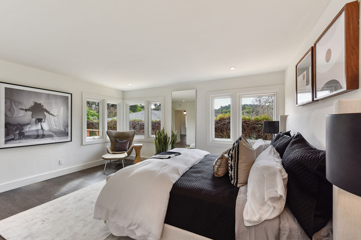 Primary bedroom with large windows and wood floors