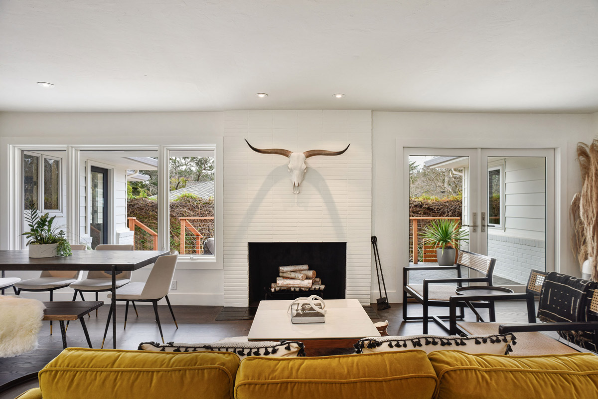 Living room featuring a large brick fireplace with large windows on both sides