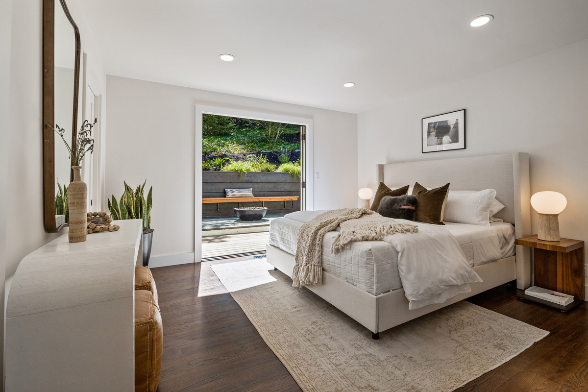 Primary bedroom showing open French doors leading outside