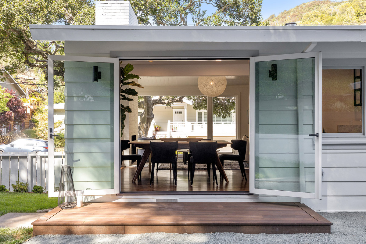 Exterior view of the home, showing the deck and dining room beyond