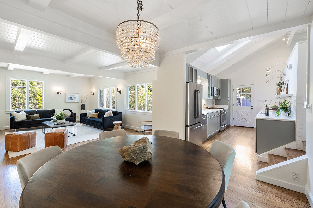 Open floor plan view of the dining room living room, and kitchen, featuring wood floors throughout